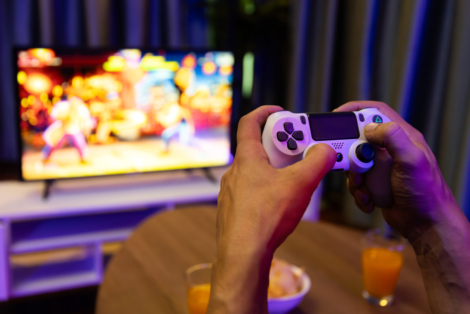 Home close up of hand's man player using joystick on fighting game screen. postulate.