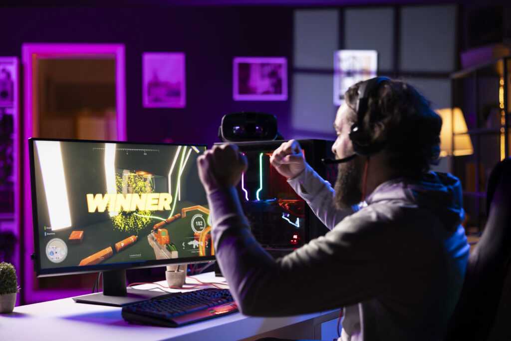 esports player playing videogames celebrating after winning online match