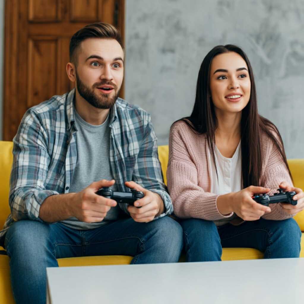 man woman are sitting couch holding remotes