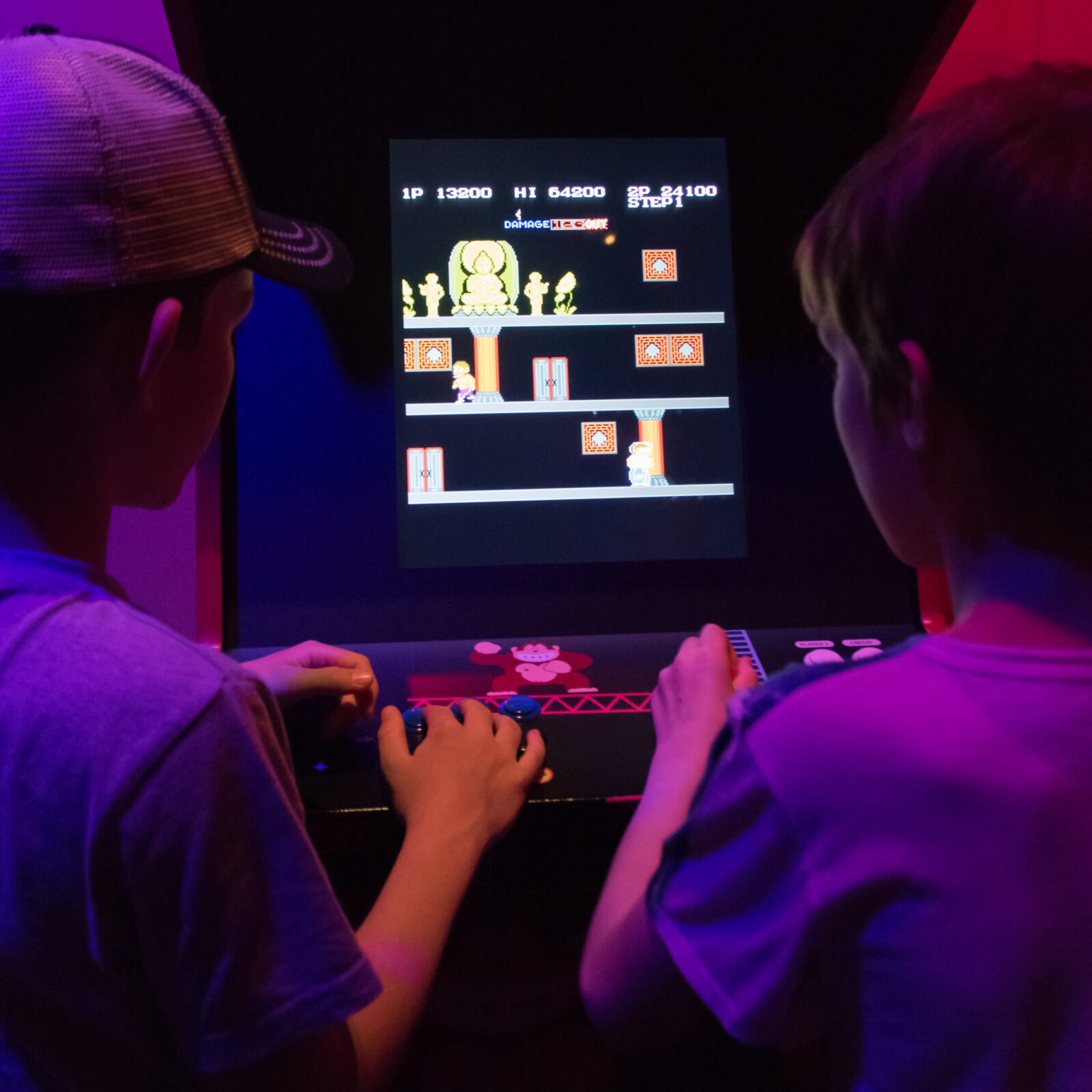 two children playing old arcade game